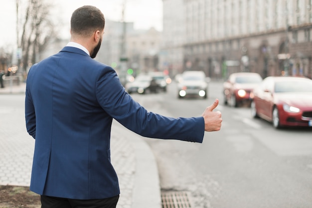 Kostenloses Foto geschäftsmann, der taxi krabbt