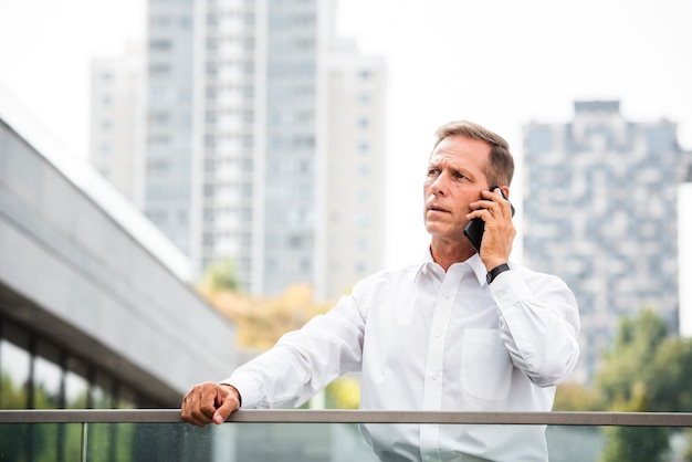 Geschäftsmann, der telefonisch sich bespricht