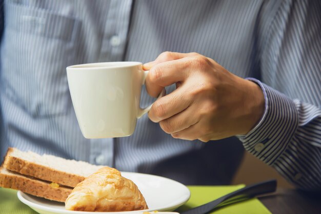 Geschäftsmann essen das amerikanische Frühstück, das in ein Hotel eingestellt wird