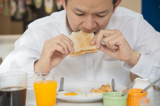 Geschäftsmann essen das amerikanische Frühstück, das in einem Hotel eingestellt wird