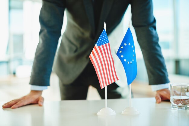 Geschäftsmann hinter Europäische und amerikanische Flaggen