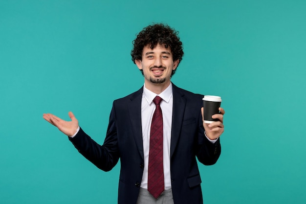 Geschäftsmann hübscher süßer junger Kerl im schwarzen Anzug und roter Krawatte glücklich und mit Kaffeetasse