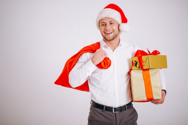 Geschäftsmann im Sankt-Hut, der Weihnachtsgeschenk lokalisiert hält