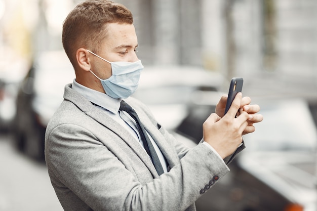 Geschäftsmann in einer Stadt. Person in einer Maske. Kerl mit Telefon.