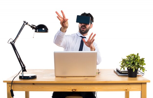Geschäftsmann in seinem Büro mit VR Brille