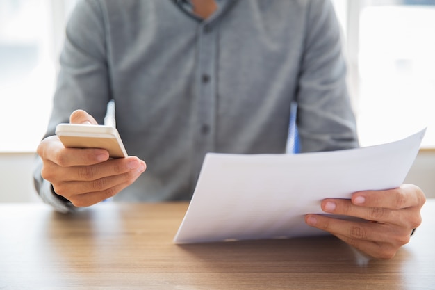 Geschäftsmann Lesung Dokument und SMS-Nachricht