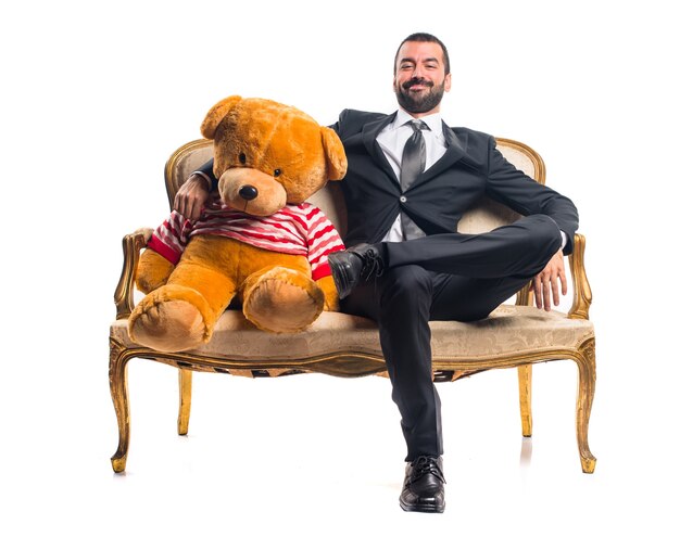 Geschäftsmann mit Teddy sitzt auf Vintage-Sessel