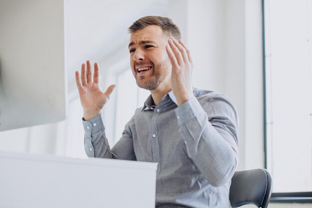 Geschäftsmann sitzt am Schreibtisch und arbeitet am Computer