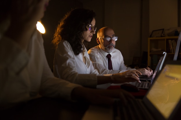 Geschäftsmann und Geschäftsfrauen, die mit Laptops arbeiten