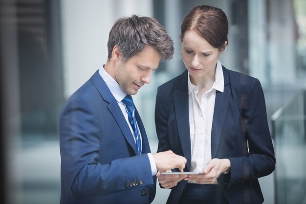 Geschäftsmann und Kollege diskutieren über digitales Tablet