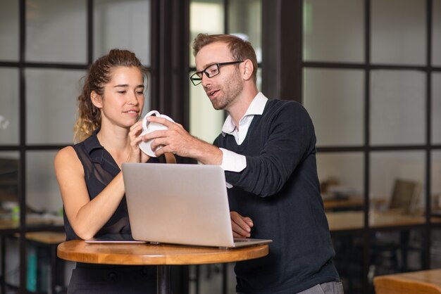 Geschäftspartner, die am Cafétisch plaudern und arbeiten.