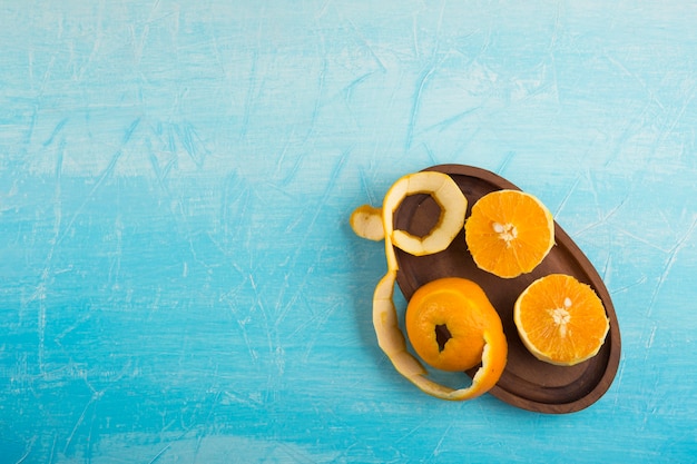 Geschälte gelbe Orane in einer Holzplatte unten