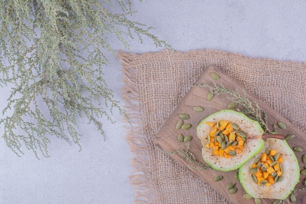 Geschälter birnensalat mit karotten- und kürbiskernen auf einem holzbrett