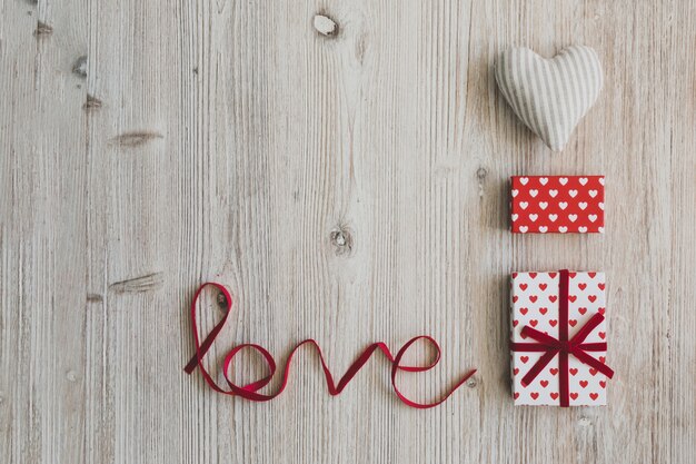 Geschenk-Boxen, ein Herz und das Wort &quot;Liebe&quot; auf einem Holztisch