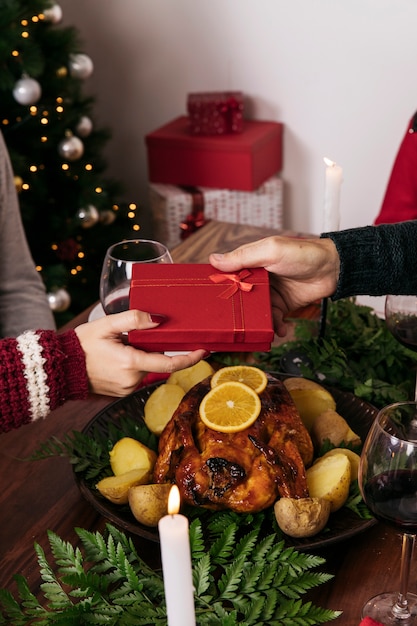 Kostenloses Foto geschenkbox an freund beim weihnachtsessen