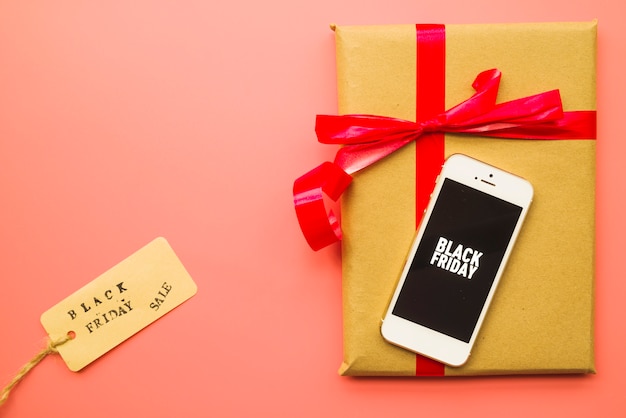 Kostenloses Foto geschenkbox mit black friday-inschrift auf smartphone