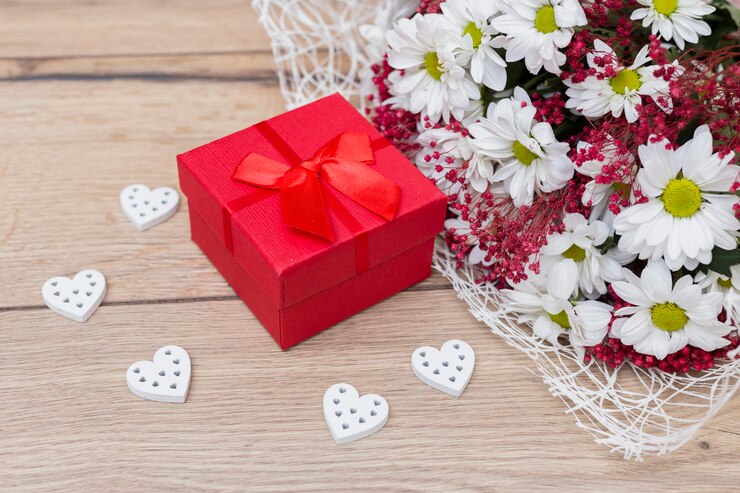 Kostenlose Foto geschenkbox mit herzen und blumenblumenstrauß auf tabelle