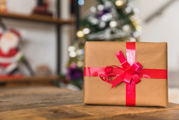 Geschenkbox mit rotem Band auf Tabelle