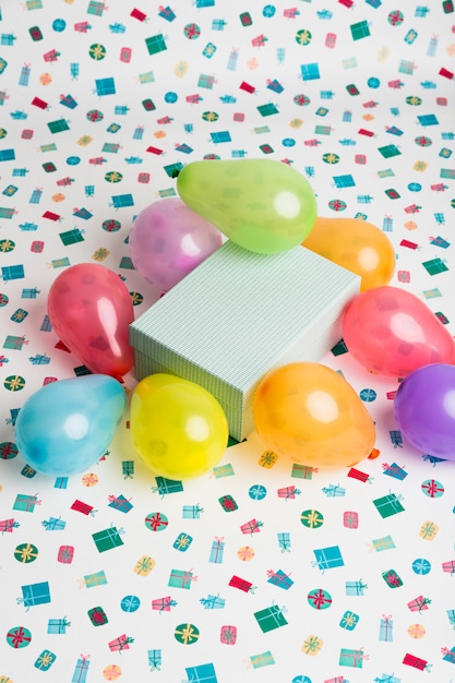 Kostenloses Foto geschenkbox zwischen hellen ballons