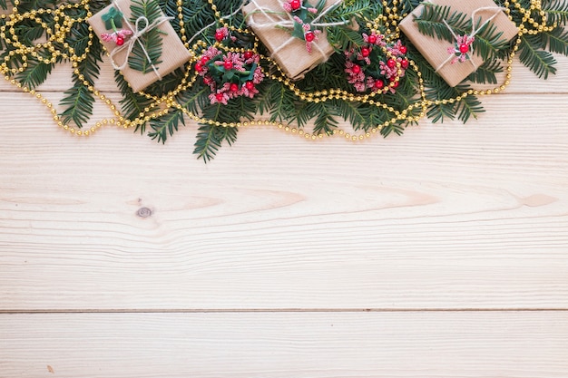 Geschenkboxen auf verziertem Tannenzweig und Perlen