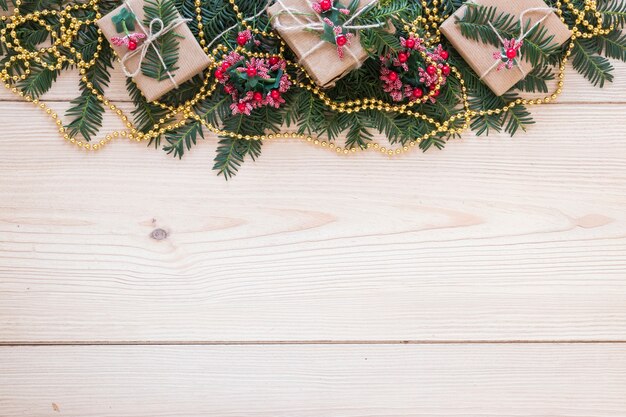 Geschenkboxen auf verziertem Tannenzweig und Perlen