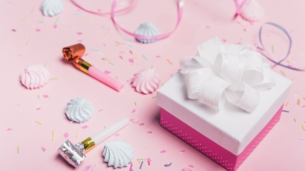 Geschenkboxen mit Süßigkeiten; streuen; Lockenband und Partei Gebläse auf rosa Hintergrund