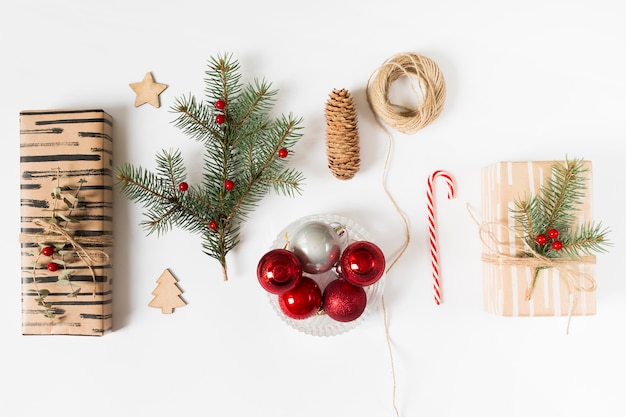 Geschenkboxen mit Tannenbaumzweig und glänzenden Kugeln