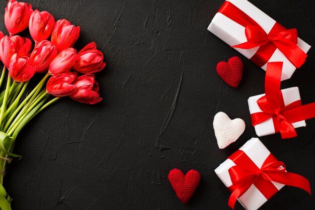 Geschenke und Blumenstrauß auf dunklem Hintergrund