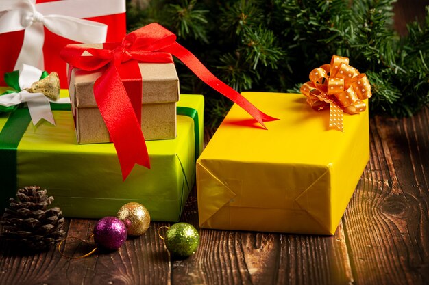 Geschenkschachteln mit Weihnachtsverzierung auf hölzernem Hintergrund