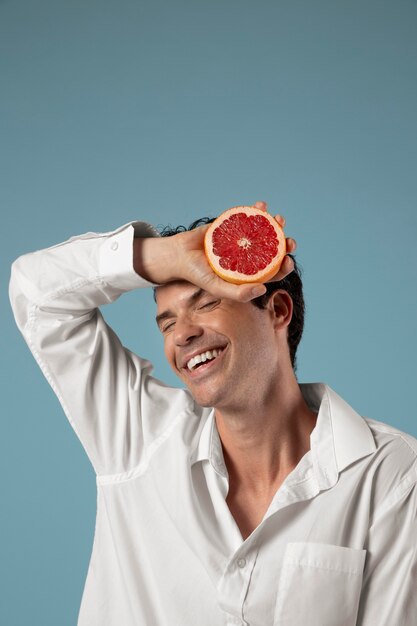 Geschlecht flüssige Person, die eine Grapefruit hält