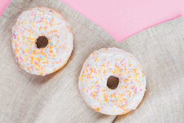 Geschmackvolle Donuts, die auf graues Gewebe legen