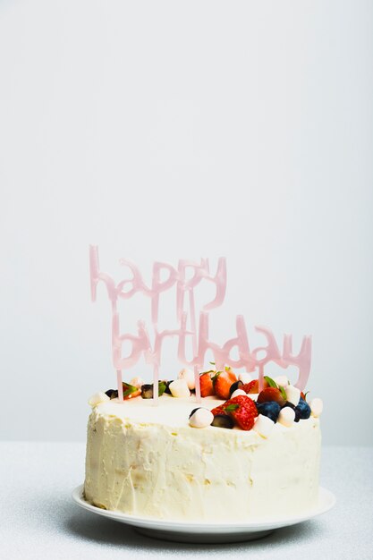 Geschmackvolle frische Torte mit Beeren und alles Gute zum Geburtstagstitel auf Teller