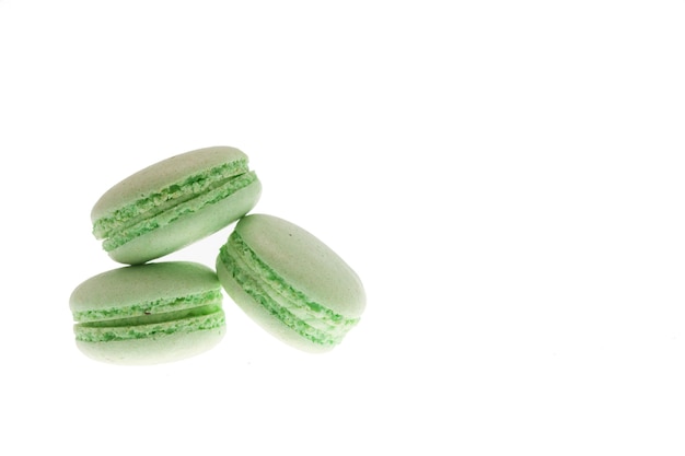 Geschmackvolle grüne makronen getrennt über weißem hintergrund. leckerer snack
