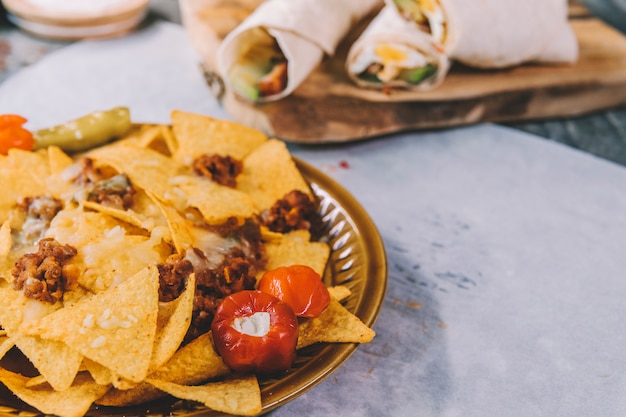 Geschmackvolle köstliche mexikanische gelbe Nachochips in der braunen Platte