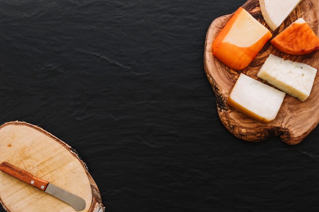 Geschmackvoller Käse und kleines Messer auf Holz