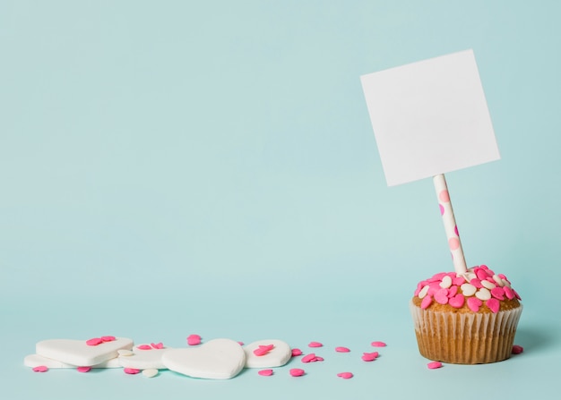 Geschmackvoller Kuchen mit Tag auf Stock und dekorativen Herzen