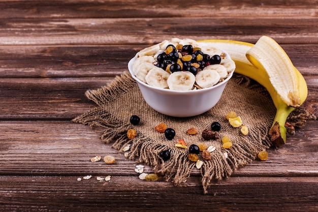Geschmackvolles gesundes Morgenfrühstück gemacht von der Milch und vom Brei mit Nüssen, Bananen und Honig