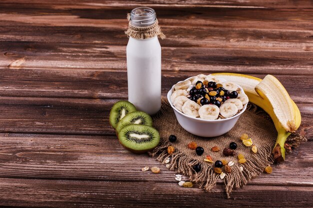 Geschmackvolles gesundes Morgenfrühstück gemacht von der Milch und vom Brei mit Nüssen, Kiwis und Honig