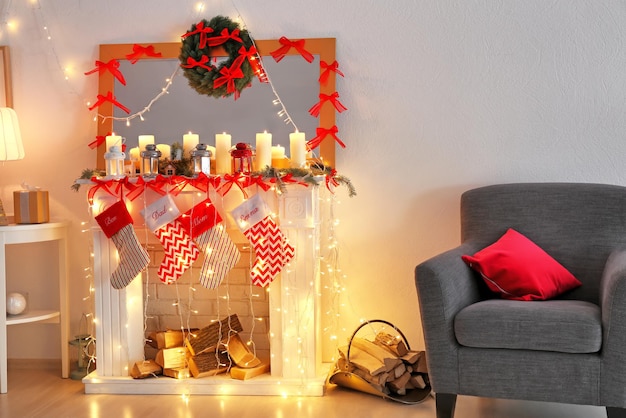 Geschmückter kamin mit weihnachtslaternen, kerzen und socken im zimmer