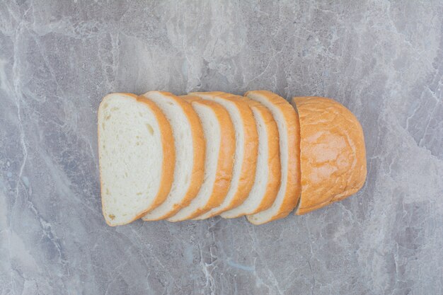 Geschnitten von frischem Brot auf Marmorhintergrund.