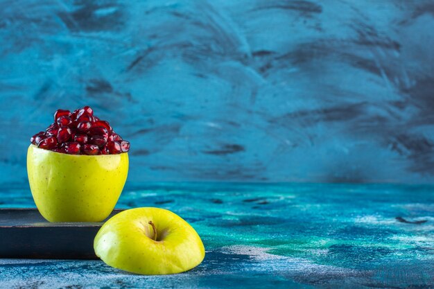 Geschnittene Apfel- und Granatapfelkerne auf einer Holzplatte