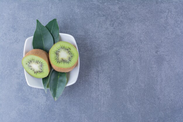 Geschnittene Kiwis in einer Schüssel auf der dunklen Oberfläche