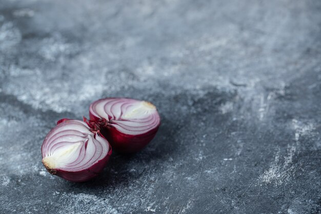 Geschnittene lila Zwiebel auf Marmorhintergrund.