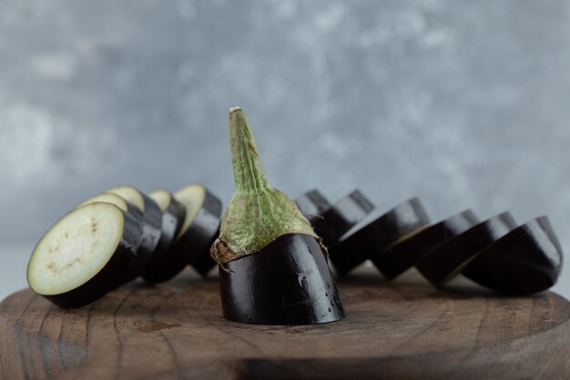 Geschnittene rohe Aubergine auf Holzbrett. Nahaufnahme Foto.