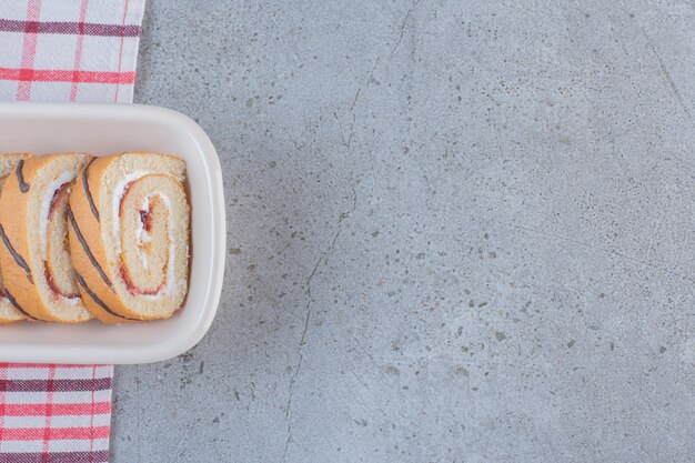 Geschnittene süße Brötchen mit Vanillegeschmack auf weißem Teller.