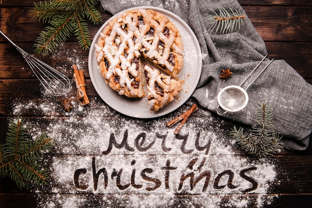 Geschnittene Torte mit Mitteilung der frohen Weihnachten