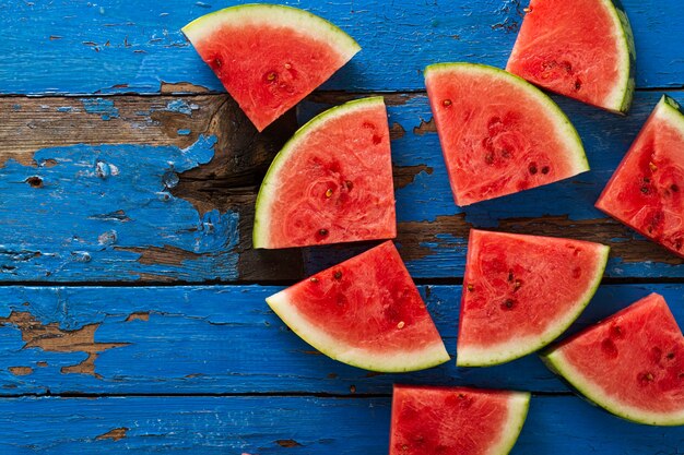 Geschnittene Wassermelone Draufsicht. Viele Scheiben auf einem alten, rustikalen blauen Tisch. Seitenaufbau mit Kopie Raum. Essen Backrgound.