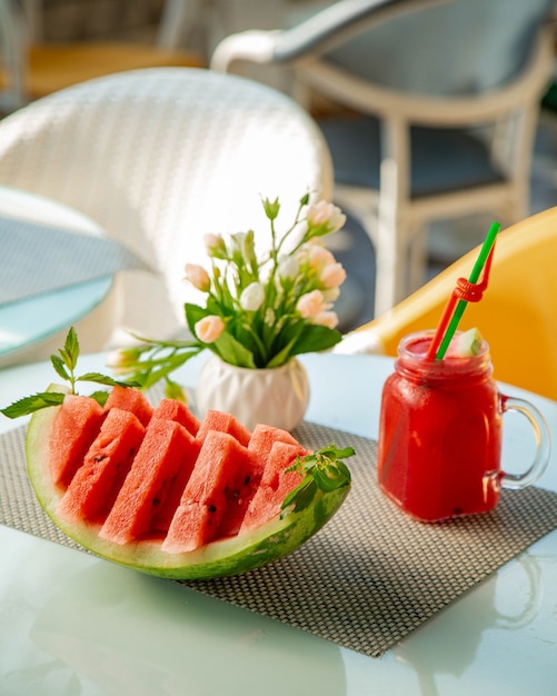 Geschnittene Wassermelone und ein Glas mit Wassermelonensäften