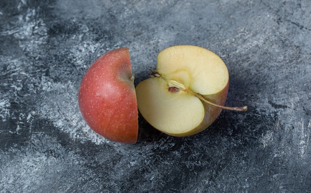Geschnittener frischer roter Apfel auf Marmorhintergrund.