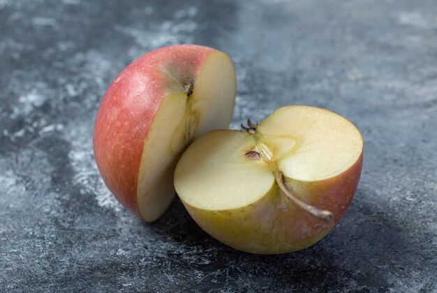 Geschnittener frischer roter Apfel auf Marmorhintergrund.